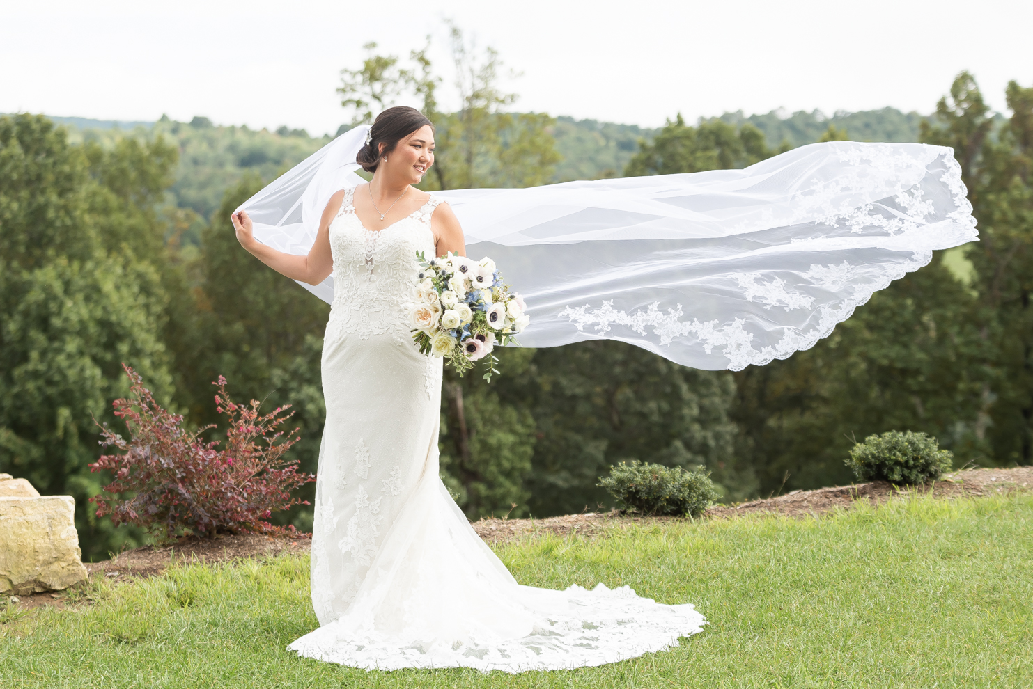 Bride holding flowing veil in the mountains of North carolina